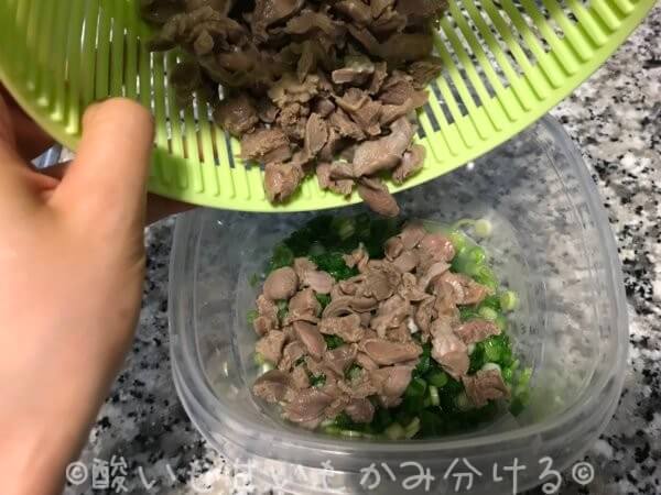 湯だった砂肝をネギとレモン汁の入ったタッパーに入れる