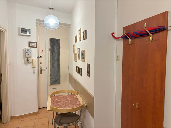 Paprika Apartment Studio内入口付近のミニダイニングテーブルセットとコートラック