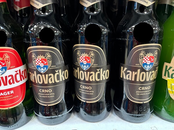 クロアチアのスーパーの棚に並べられた、Karlovačko Crno（カルロヴァチュコ・ツルノ）の黒ビールの瓶