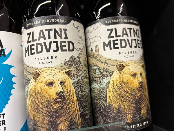 クロアチアのショップの棚に並ぶ、結構ガチめのクマのイラストが描かれたMedvedgrad醸造所のZlatni Medvjed（黄金のクマ）のビール瓶