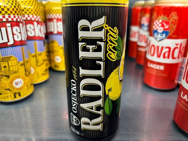 スーパーの棚に並ぶ、黒地に大きくRADLERと筆記体でcrni（黒）の文字、そしてレモンのイラストが描かれたOsječko（オシイェツコ）の缶ビール