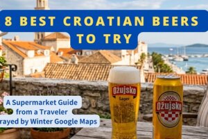 A tall glass of frothy golden beer sits on a rustic wooden table with an open Ožujsko can on a Split patio overlooking the Old Town rooftops and Bell Tower of Saint Domnius.