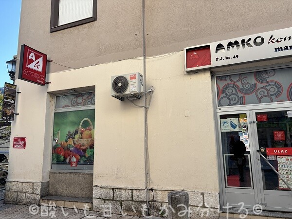 赤い看板が目印のAMKO komercスーパーマーケットの店舗入口
