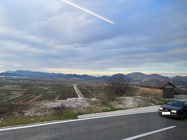ドブロブニクからスプリトへのバス移動中に左側車窓から見える山々と広大な農地の風景