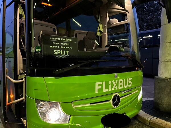 フロントガラスに「ZADAR - SKRADIN - SPLIT」の行先案内を掲示して停車している、鮮やかな緑色のFlixBus長距離バス