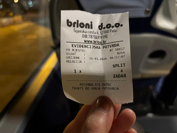 スプリトからザダル行きのBrioni Pulaバス乗車時に発行された紙の乗車確認レシートを持つ手