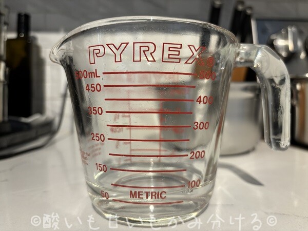 70mlの位置までぬるま湯が入ったガラス製の計量カップ