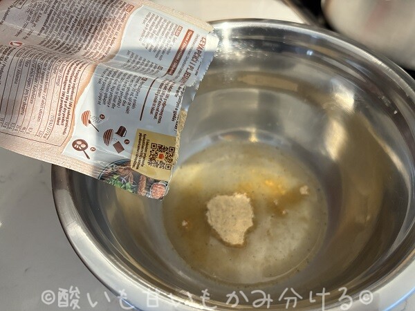 ステンレスボウル内の水にシーズニングの粉末を入れている様子