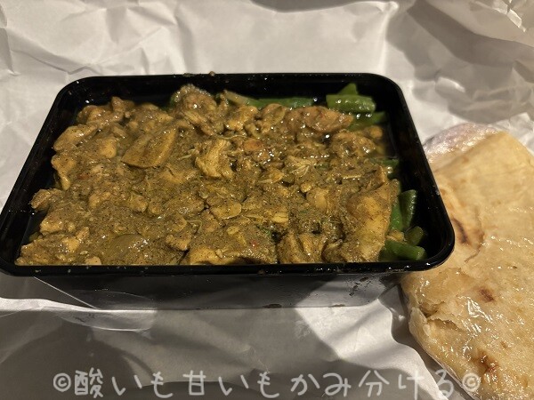 スパイシーなチキンと野菜の煮込みに生地が添えられたスリナム風ロティ